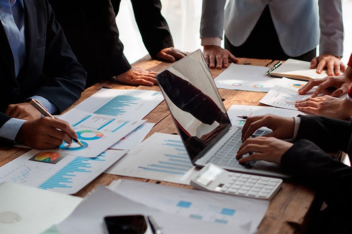 O-benchmarking-SULTS - Blog SULTS Benchmarking - equipe de trabalho em escritório com laptop e analisando dados.