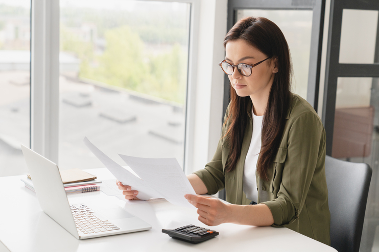 Caucasian concentrated business woman manager freelancer boss doing paperwork - Blog SULTS