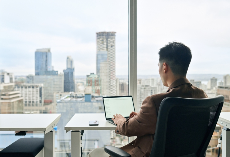 BusinessManUsingLaptopInModernOfficeCityViewSitting - Blog SULTS